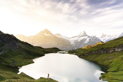 Hiker in the mist at dawn at Bachalpsee lake, Switzerland