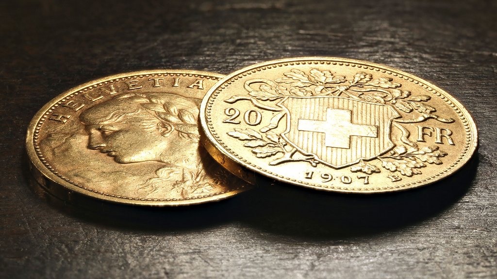 Swiss Vreneli gold coins on rustic wooden background